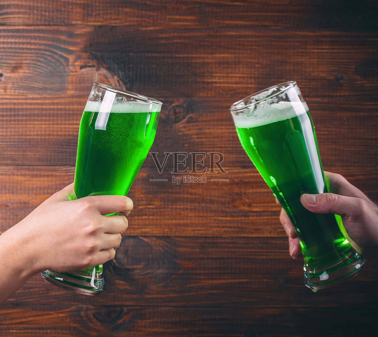 圣帕特里克节概念双手两杯绿色啤酒在木制背景下照片摄影图片