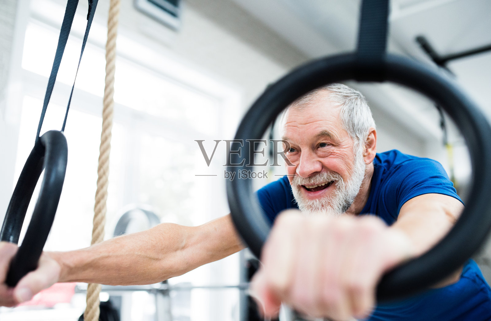 老男人在健身房练吊环照片摄影图片
