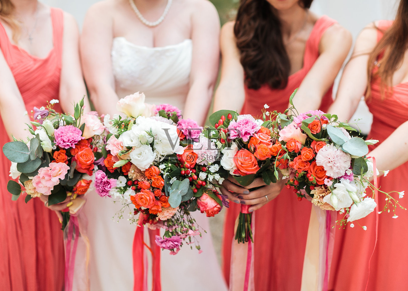 伴娘和新娘手持花束。照片摄影图片