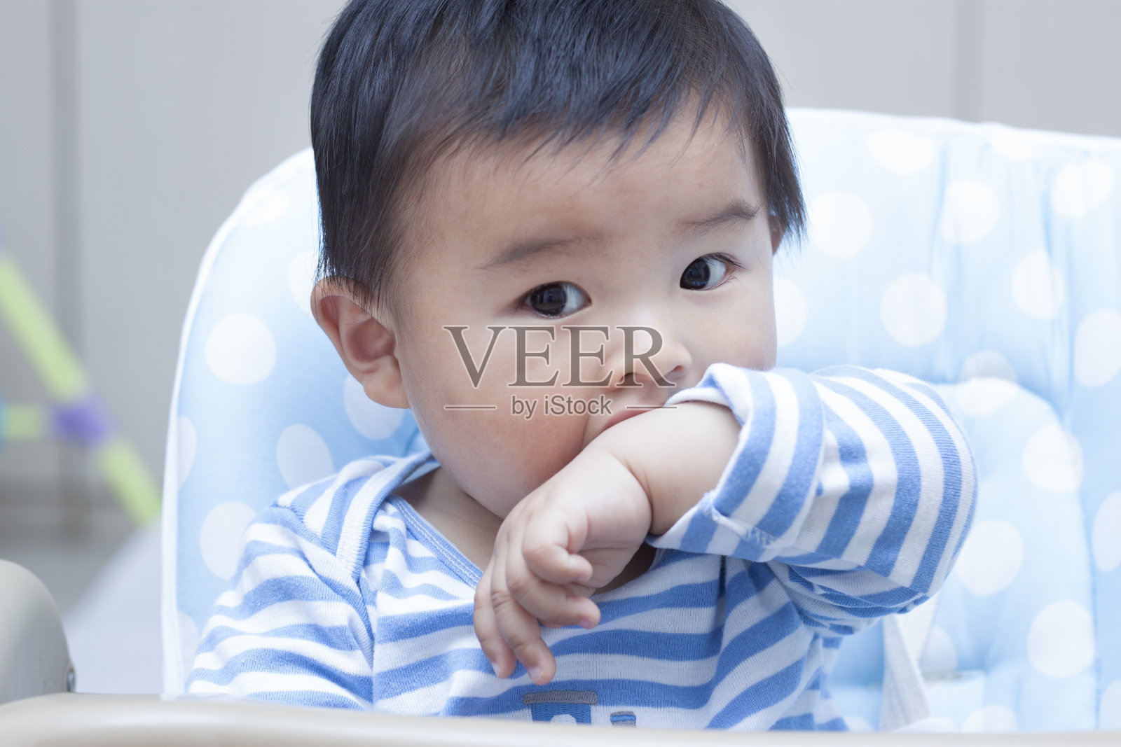 可爱的中国男婴坐在婴儿椅上照片摄影图片