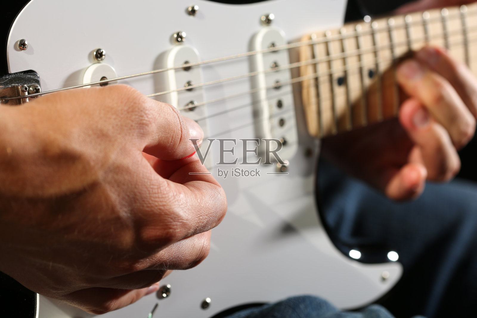 男性用拨子弹奏电吉他的特写照片摄影图片