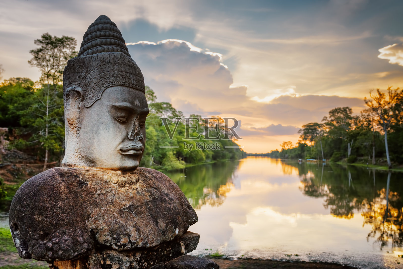 石头阿修罗和日落护城河周围柬埔寨吴哥照片摄影图片