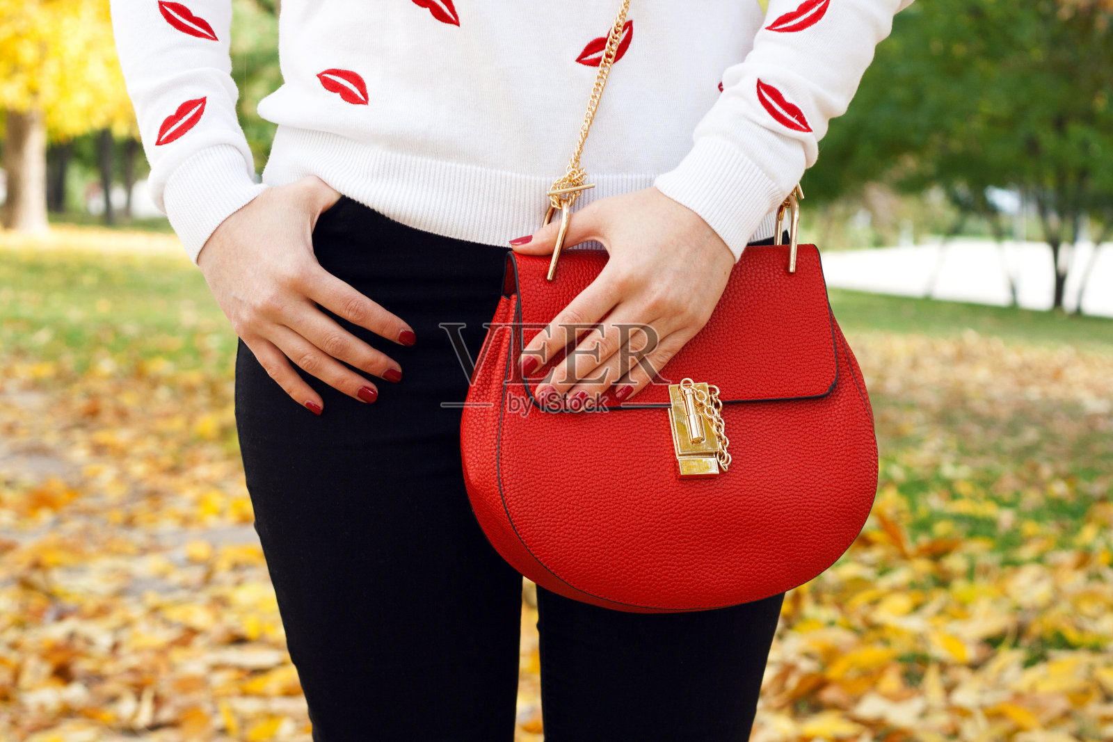 时髦的年轻女孩与红色的手提包。秋装照片摄影图片