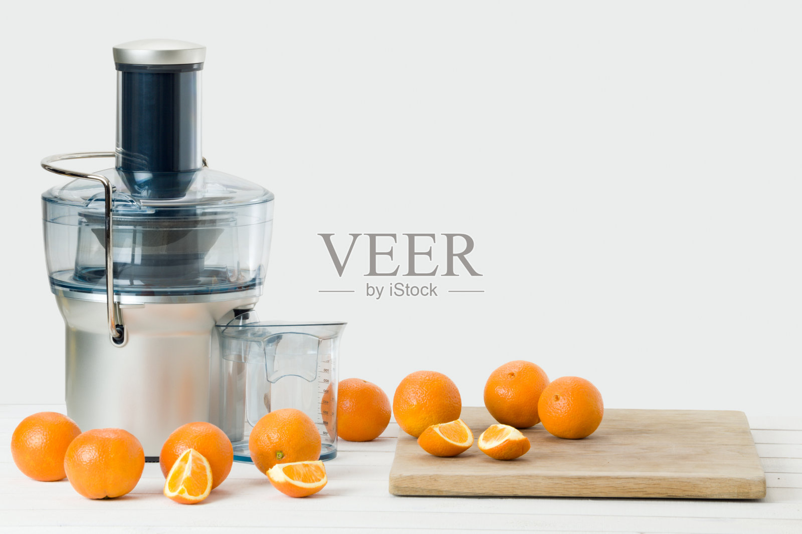 现代电动榨汁机和新鲜橙子，白色背景照片摄影图片