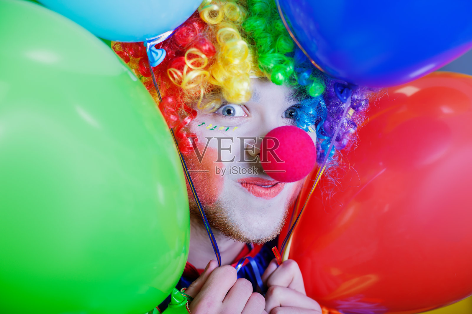 小丑和一堆彩色的气球。照片摄影图片