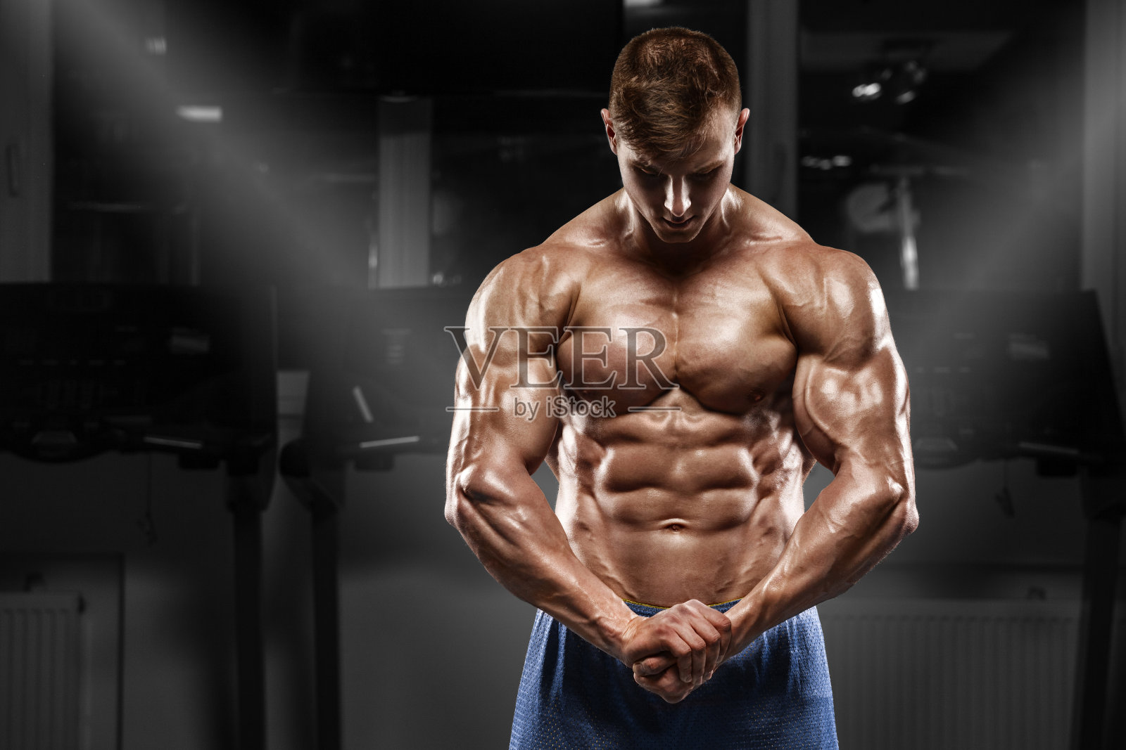 性感肌肉男在健身房摆姿势，展示肌肉，锻炼照片摄影图片