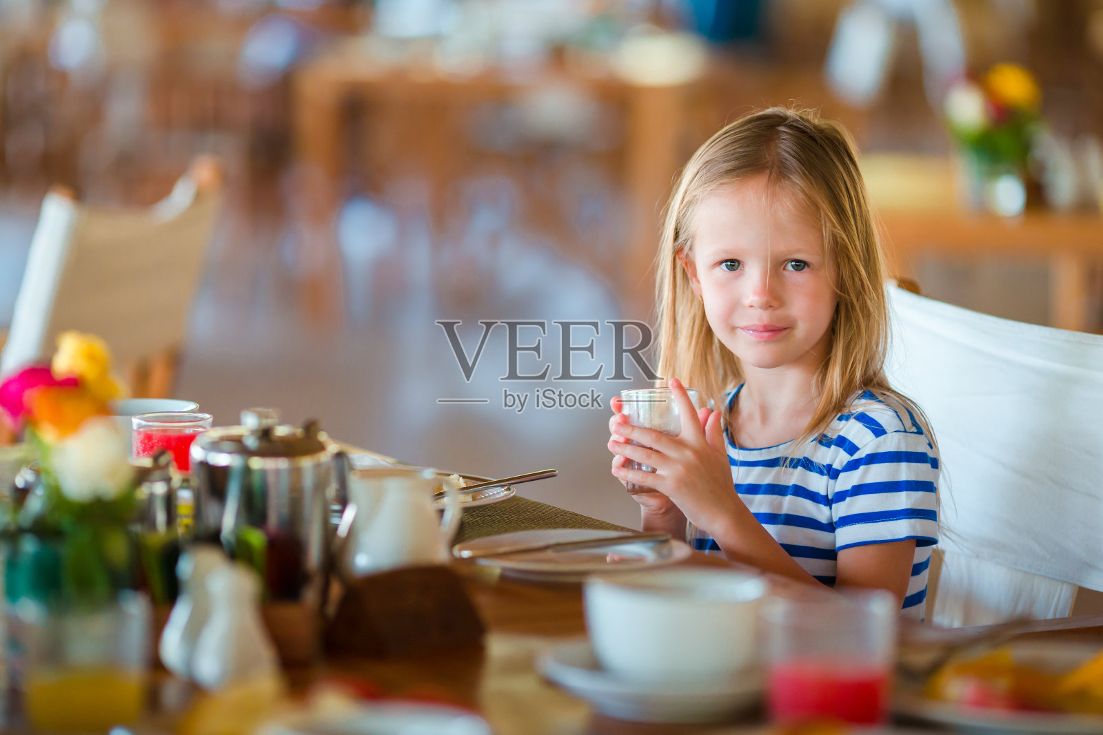 可爱的小女孩在户外咖啡厅吃早餐照片摄影图片