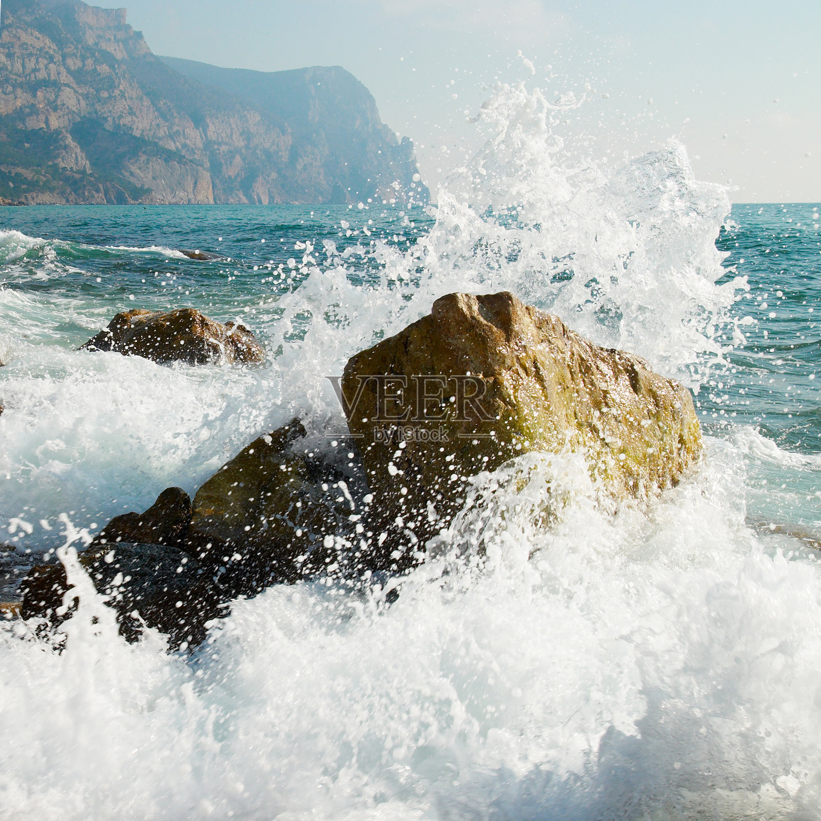 海里的波浪拍打着海里的岩石照片摄影图片