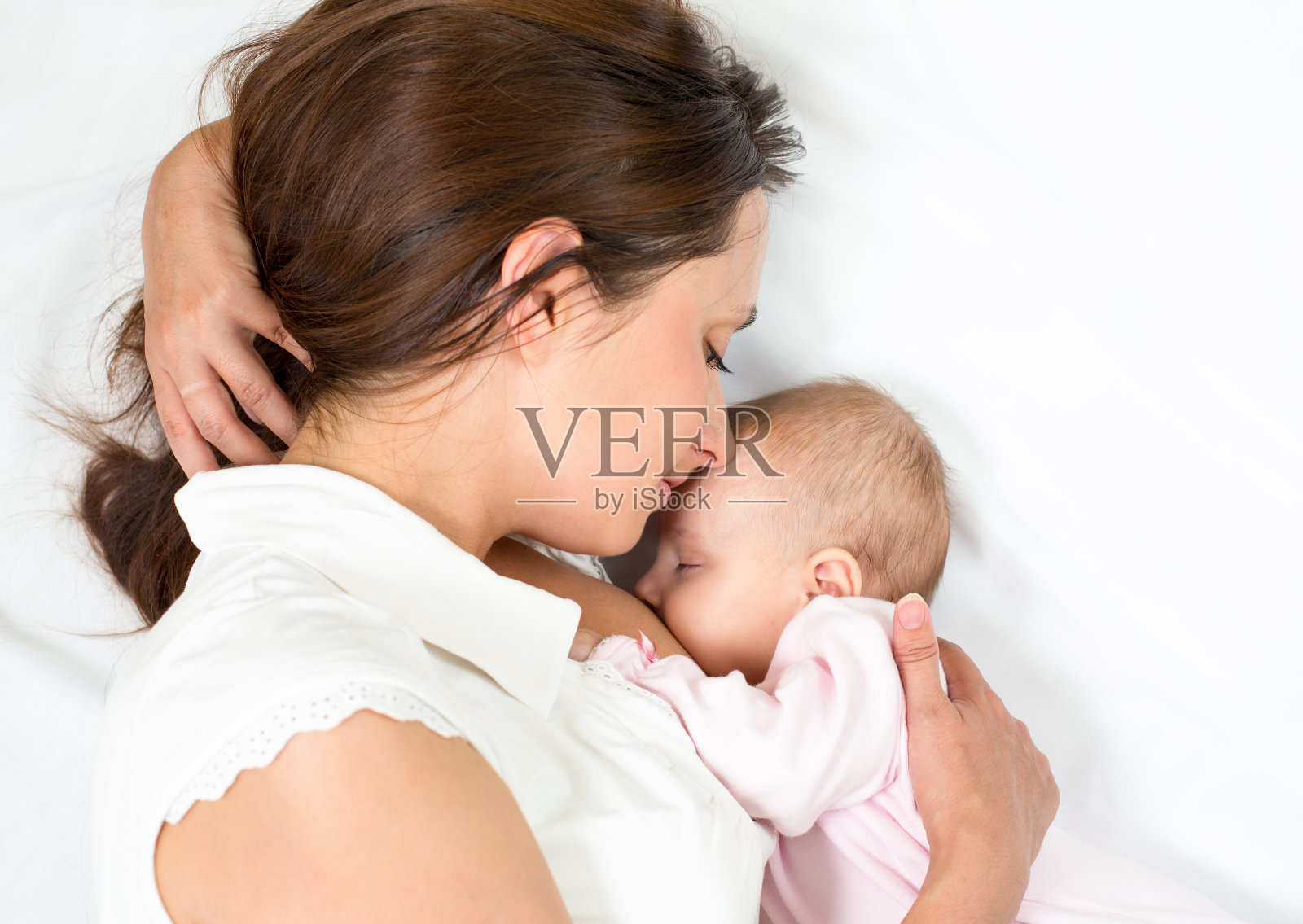 母亲躺着给女婴喂奶照片摄影图片