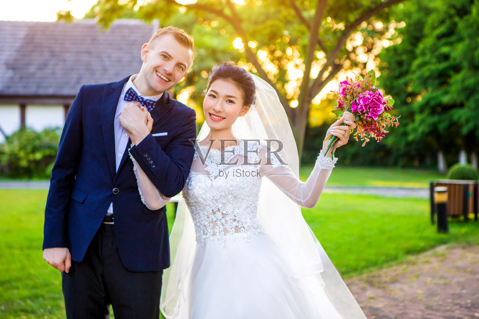 新婚夫妇手牵着手站在草坪上照片摄影图片