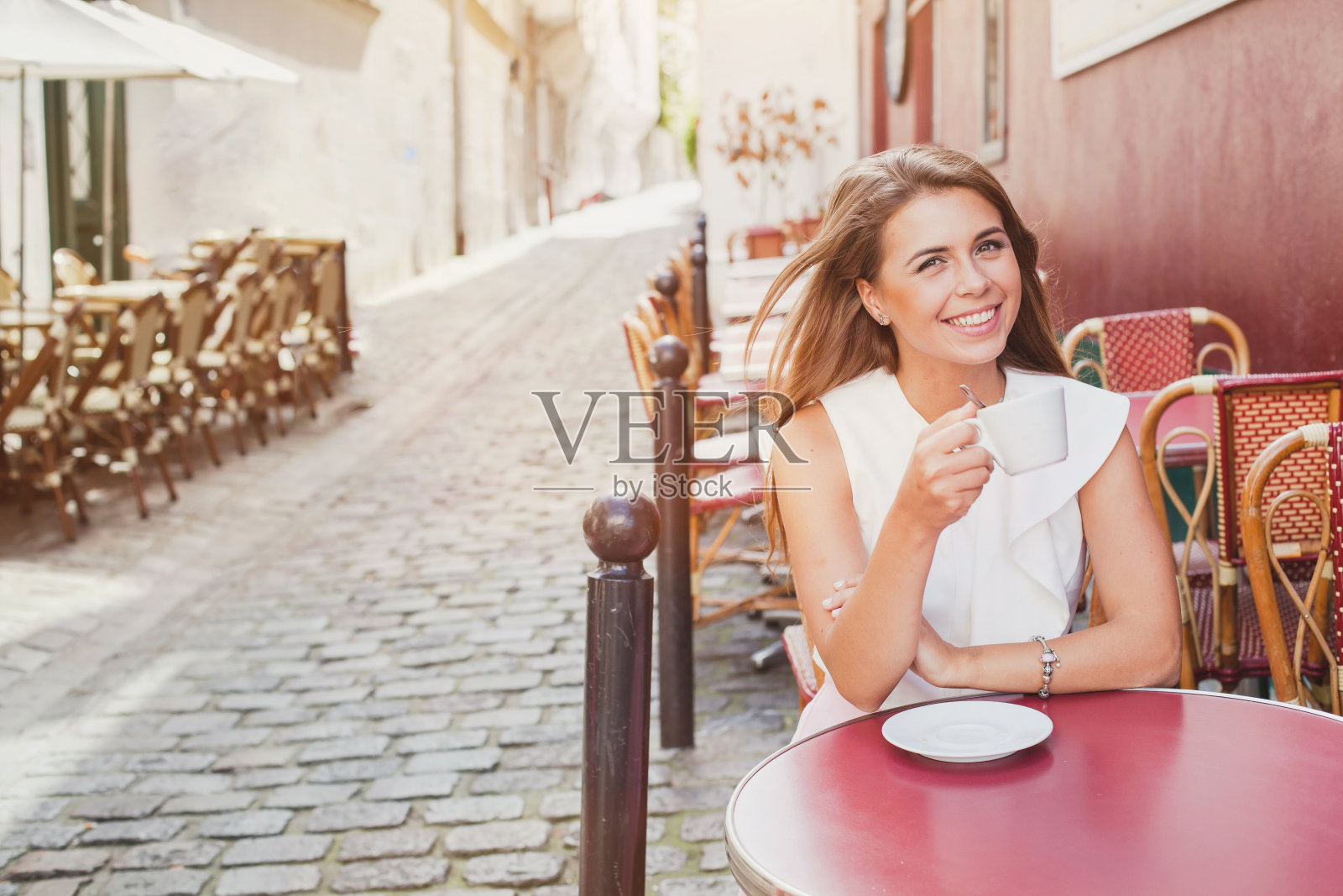 在街头咖啡馆喝咖啡的快乐女人照片摄影图片