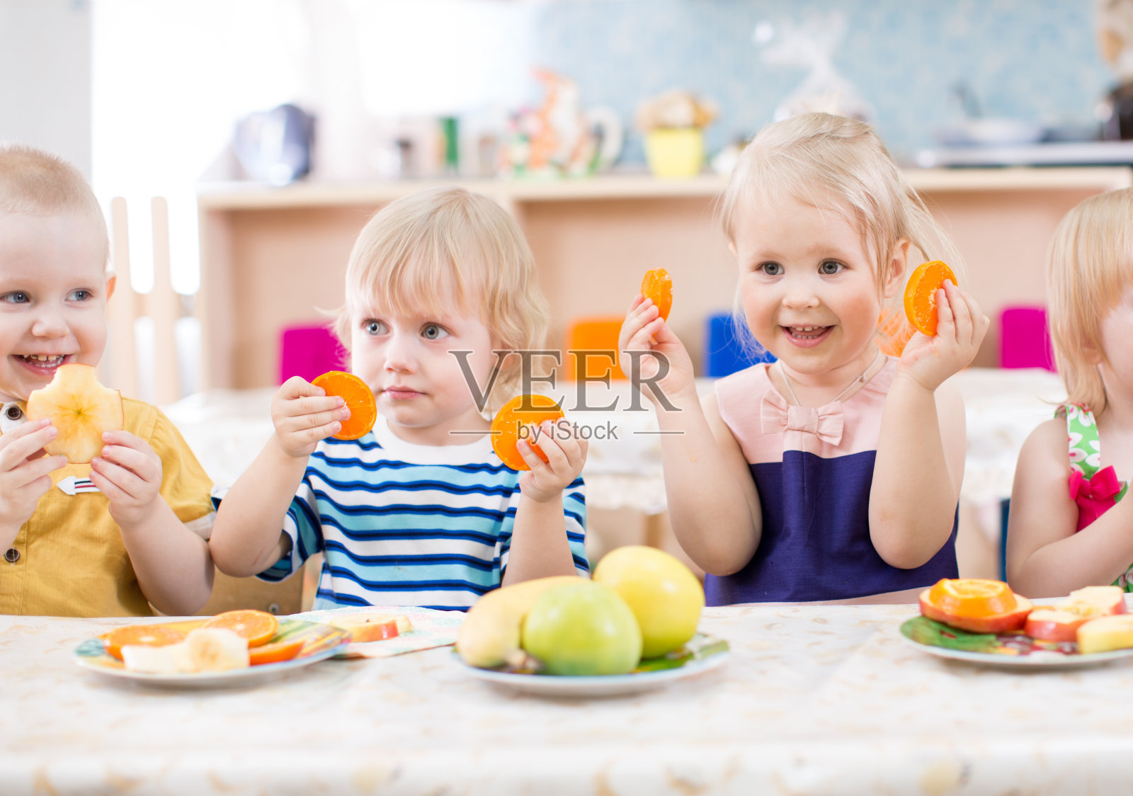 有趣的孩子们在幼儿园餐厅吃水果照片摄影图片