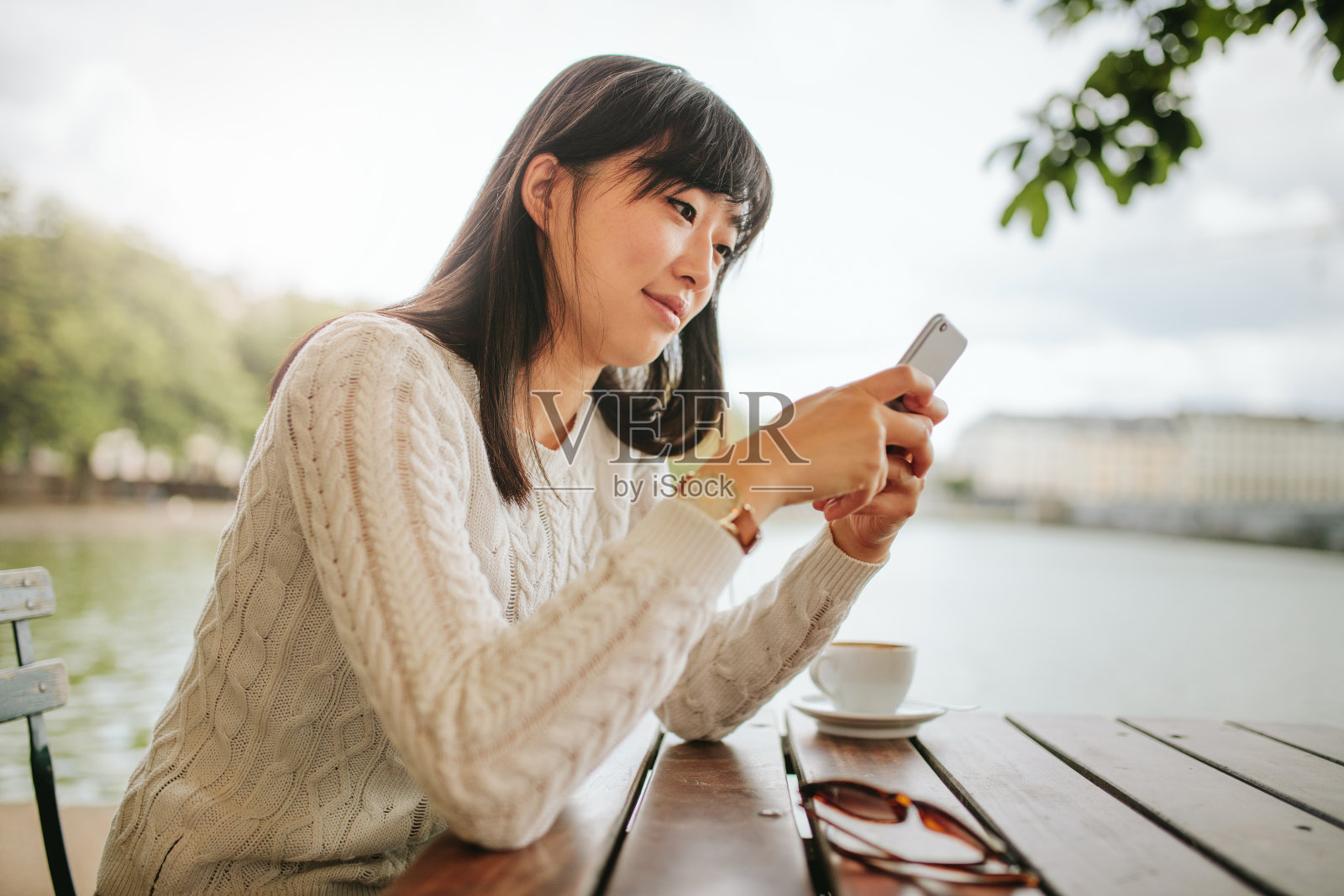 美丽的亚洲女人在咖啡馆使用手机照片摄影图片