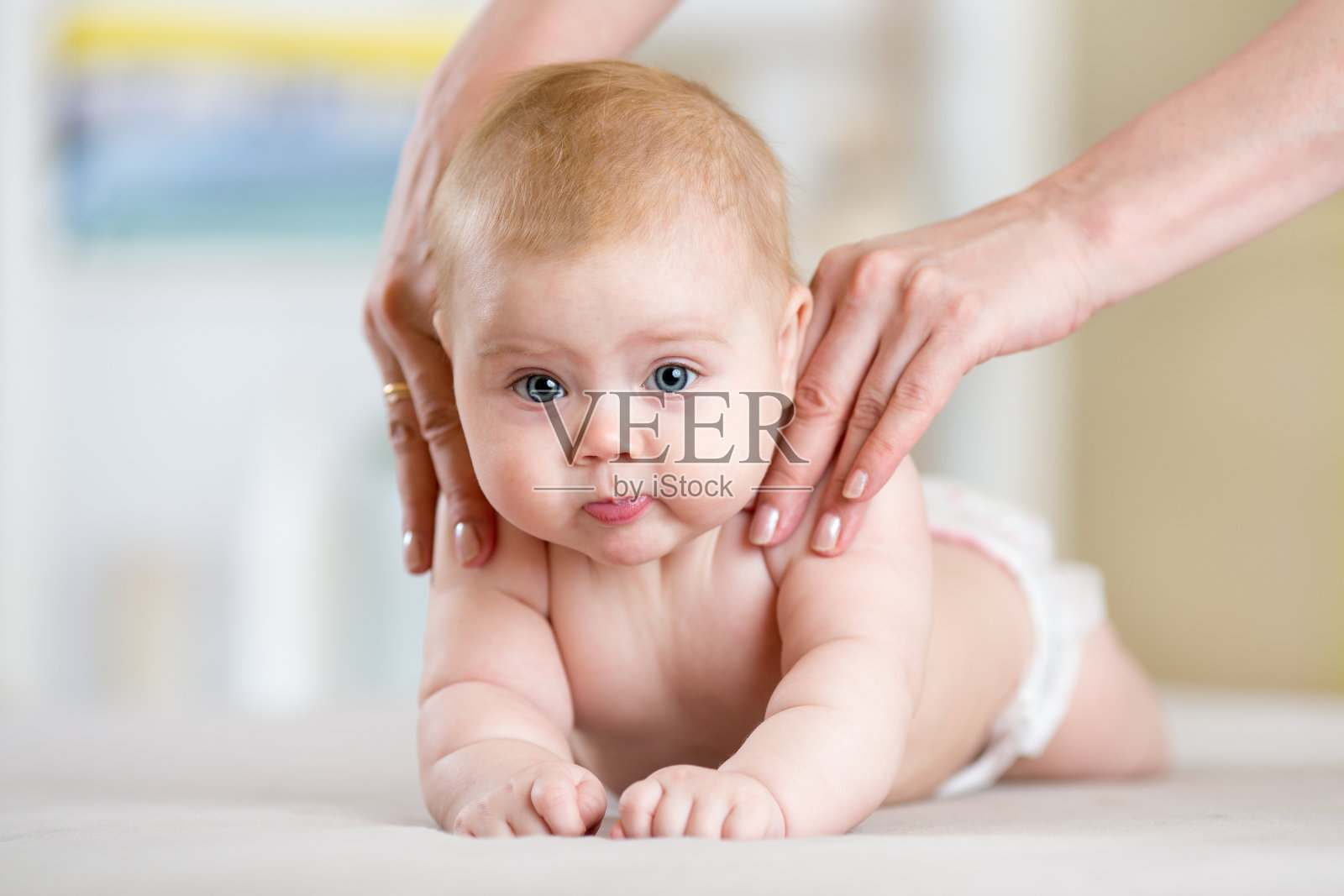 母亲或治疗师在家给她的宝宝做按摩照片摄影图片