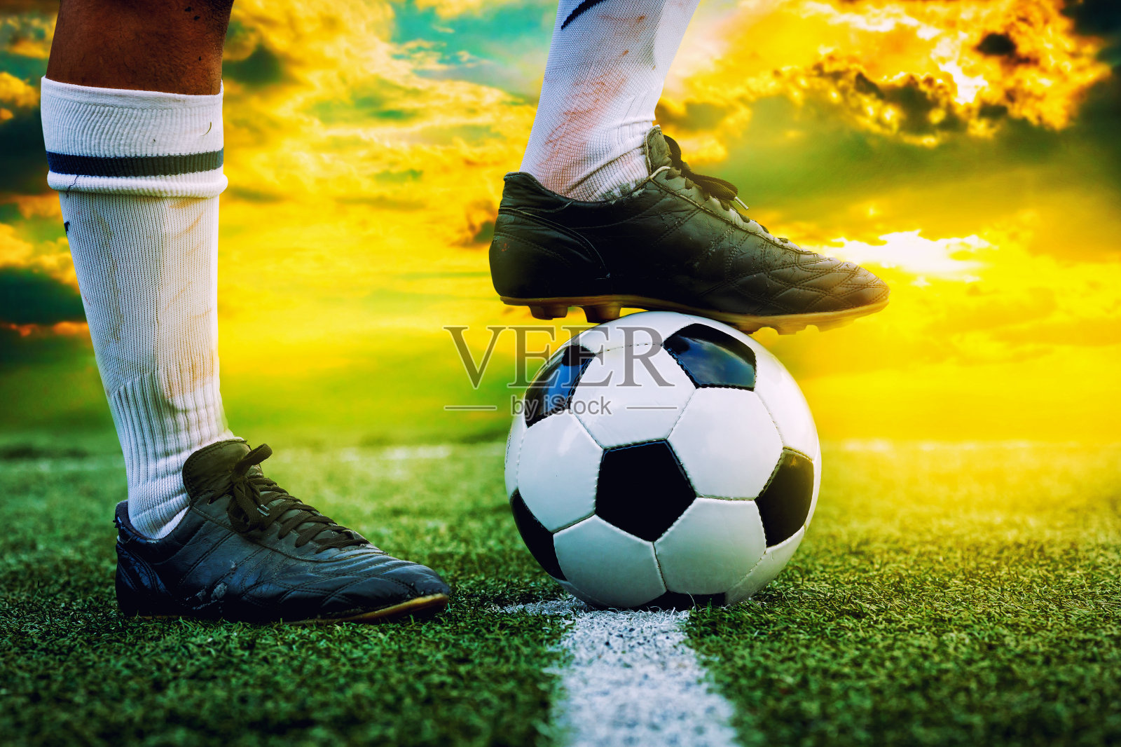 足球运动员的脚踩在足球上照片摄影图片