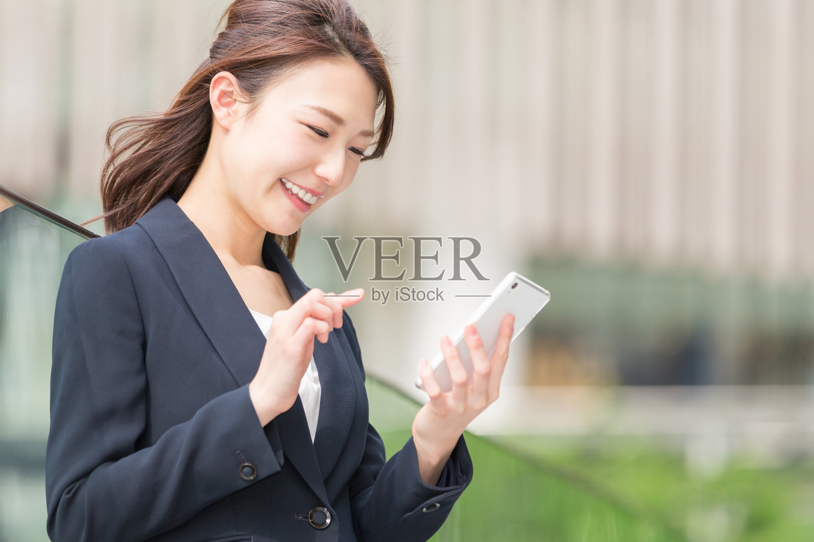 拿着智能手机的日本商务女性照片摄影图片