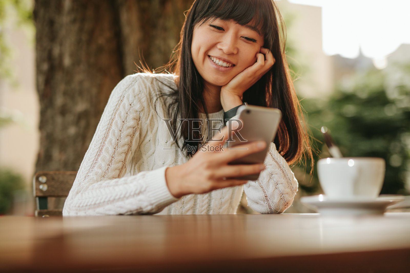 快乐的年轻女子在咖啡馆用手机照片摄影图片