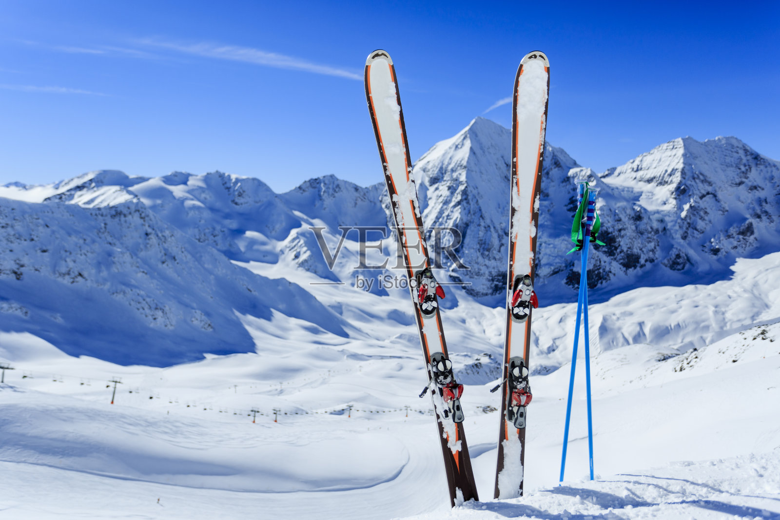 在山的背景下，滑雪齿轮卡在雪中的图像照片摄影图片