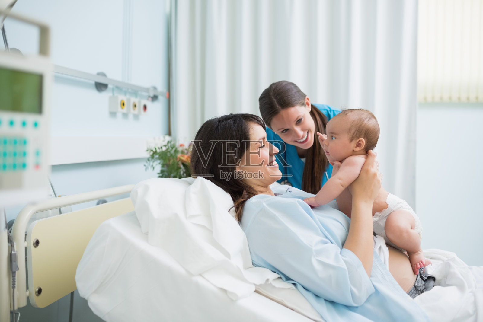医生和母亲抱着穿尿布的男婴照片摄影图片
