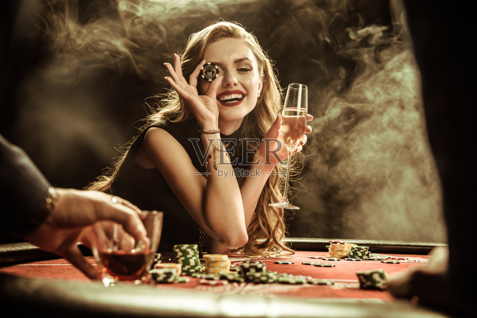 带着饮料和扑克筹码的微笑女人的肖像照片摄影图片