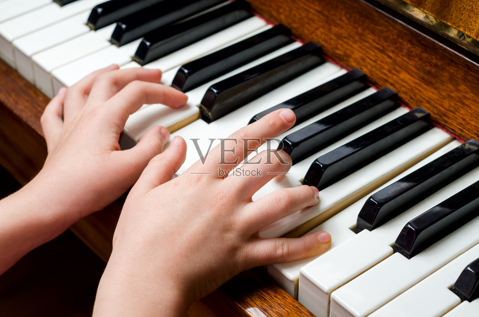 孩子用手弹奏钢琴照片摄影图片