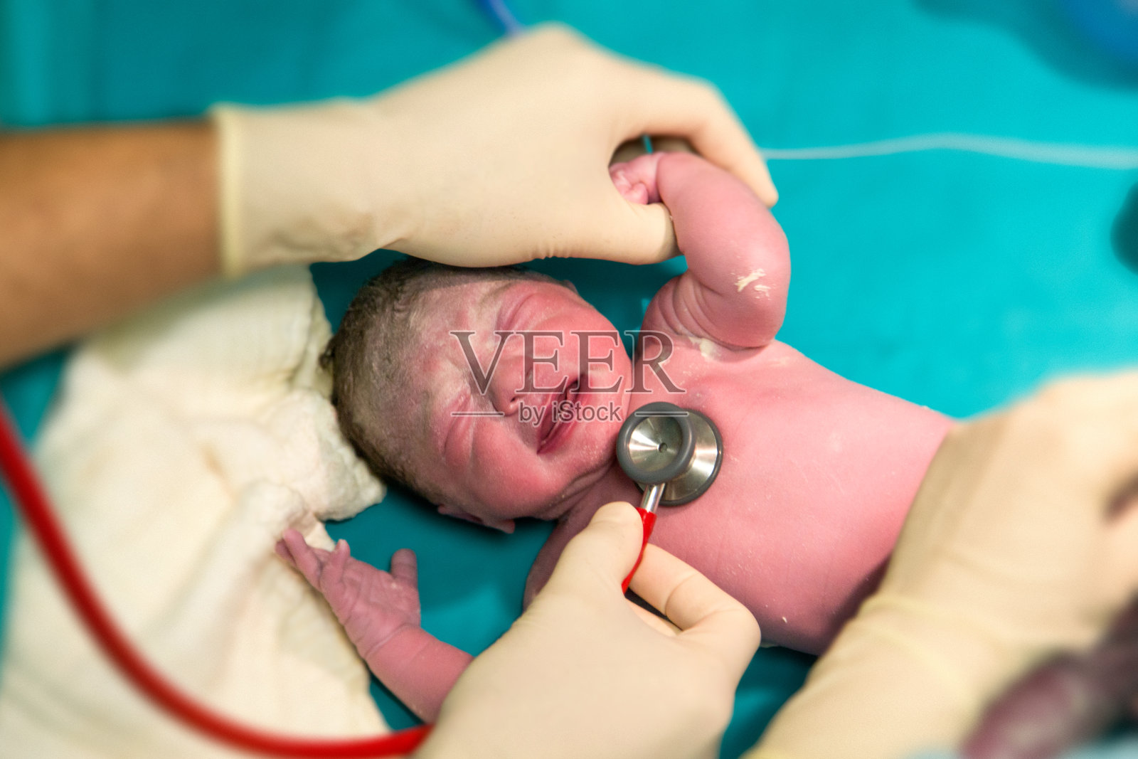 全新的婴儿。刚出生的女婴正在接受医生的检查照片摄影图片