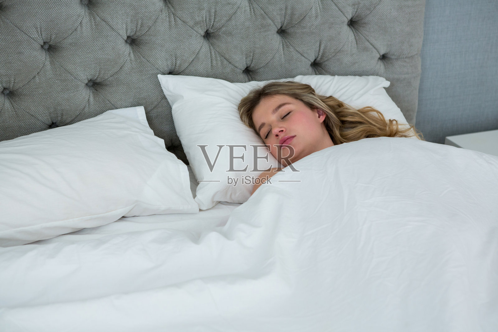 年轻女子睡在自己的床上照片摄影图片