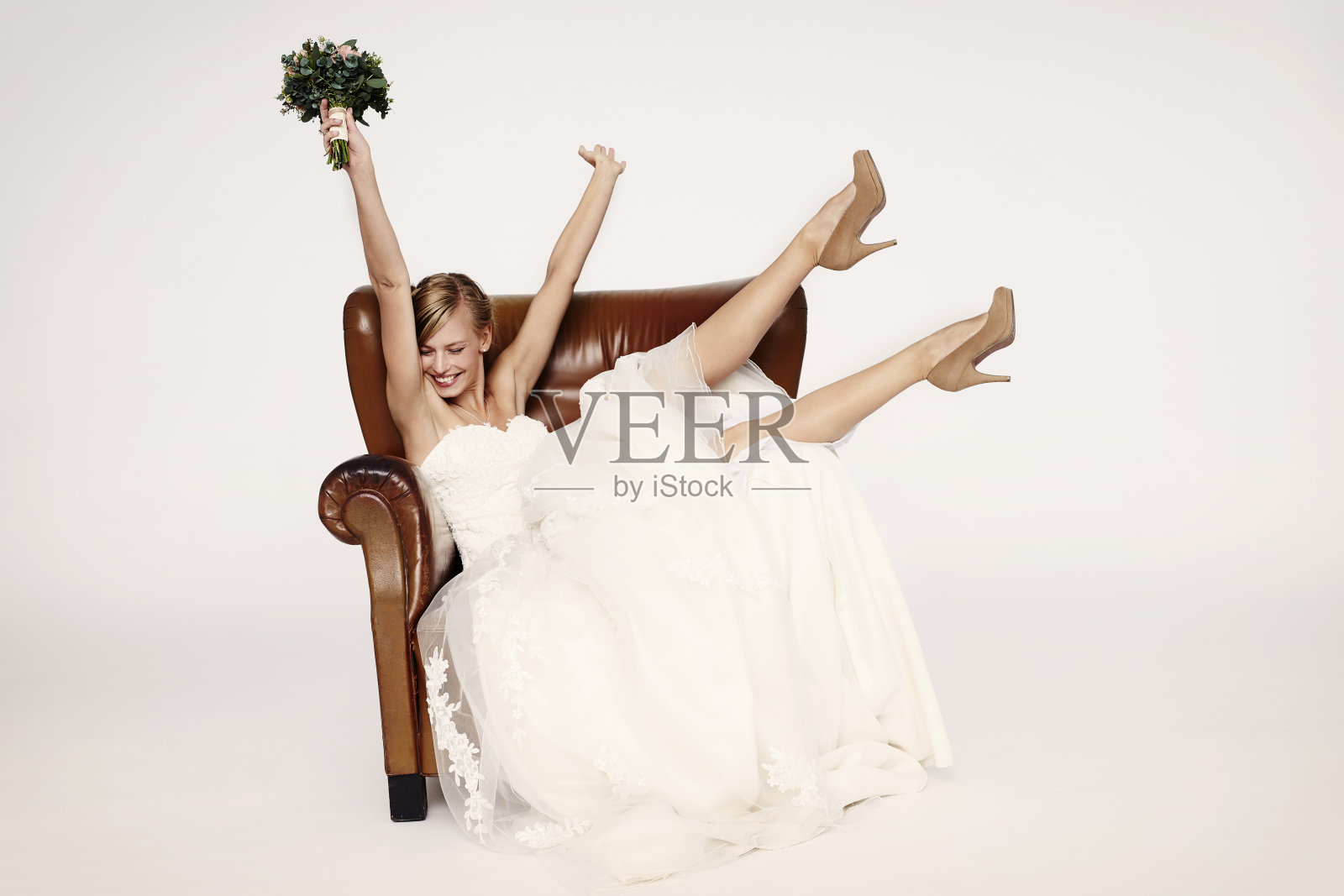 扶手椅里的兴奋新娘照片摄影图片