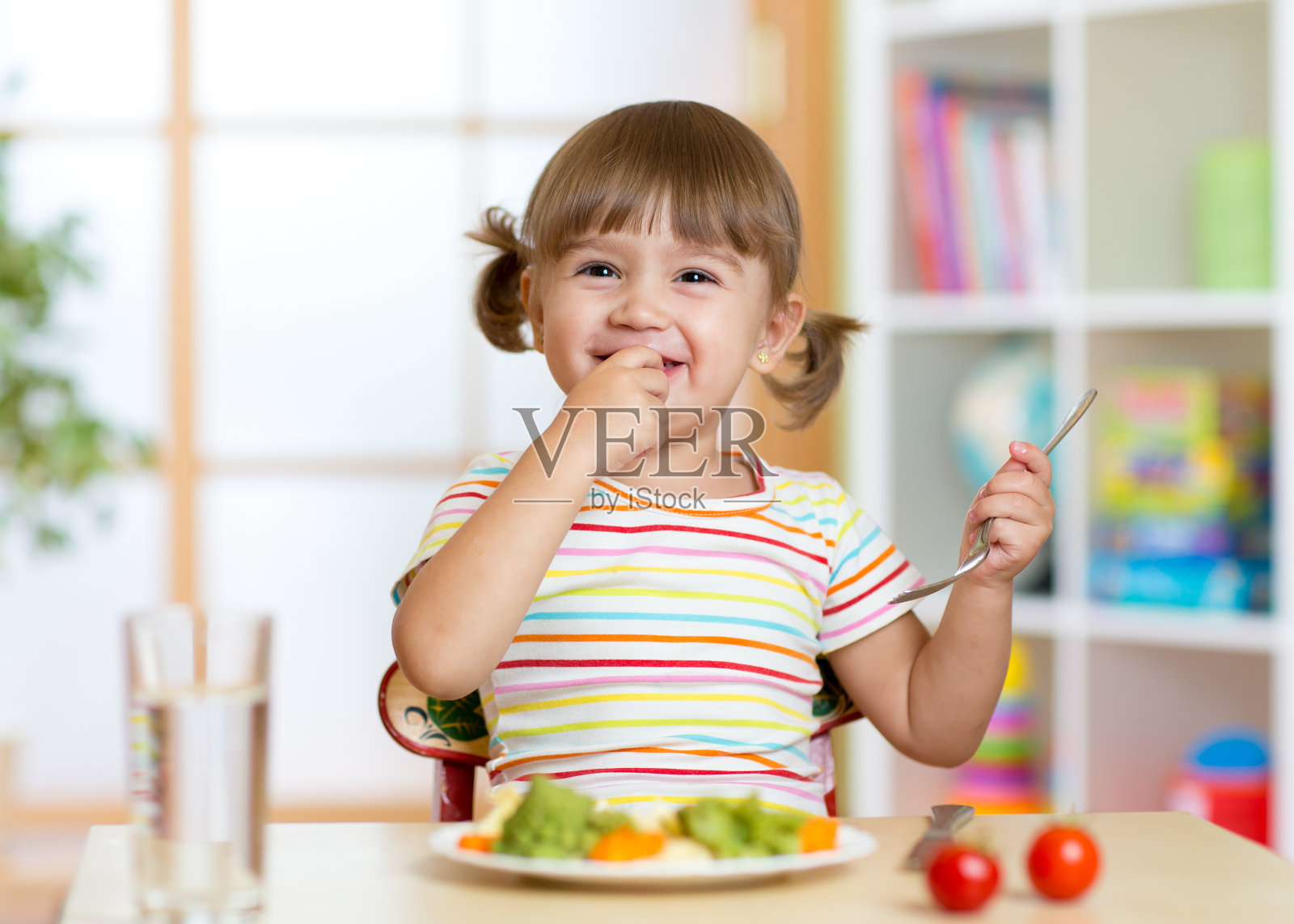 有趣的小女孩在幼儿园吃健康食品照片摄影图片