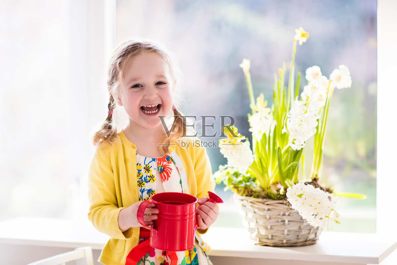 可爱的小女孩浇灌春天的第一朵花照片摄影图片