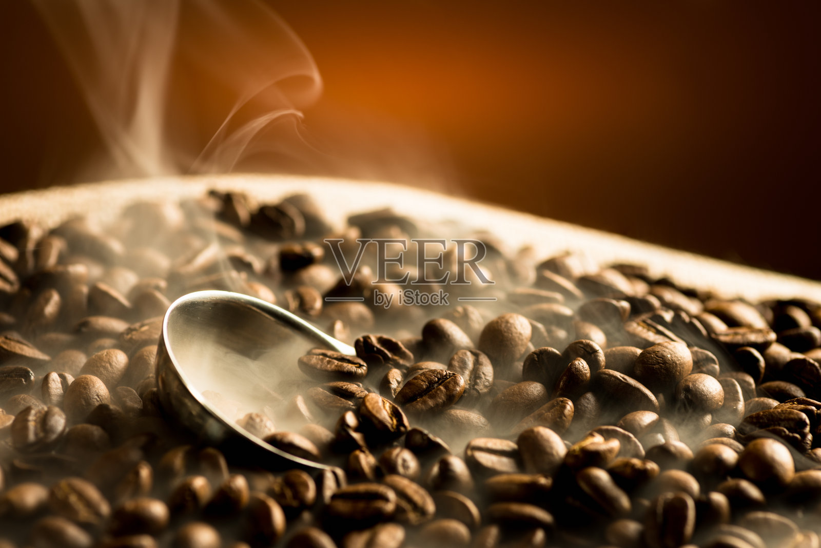 在黑暗的背景下，用烟烘焙咖啡豆照片摄影图片