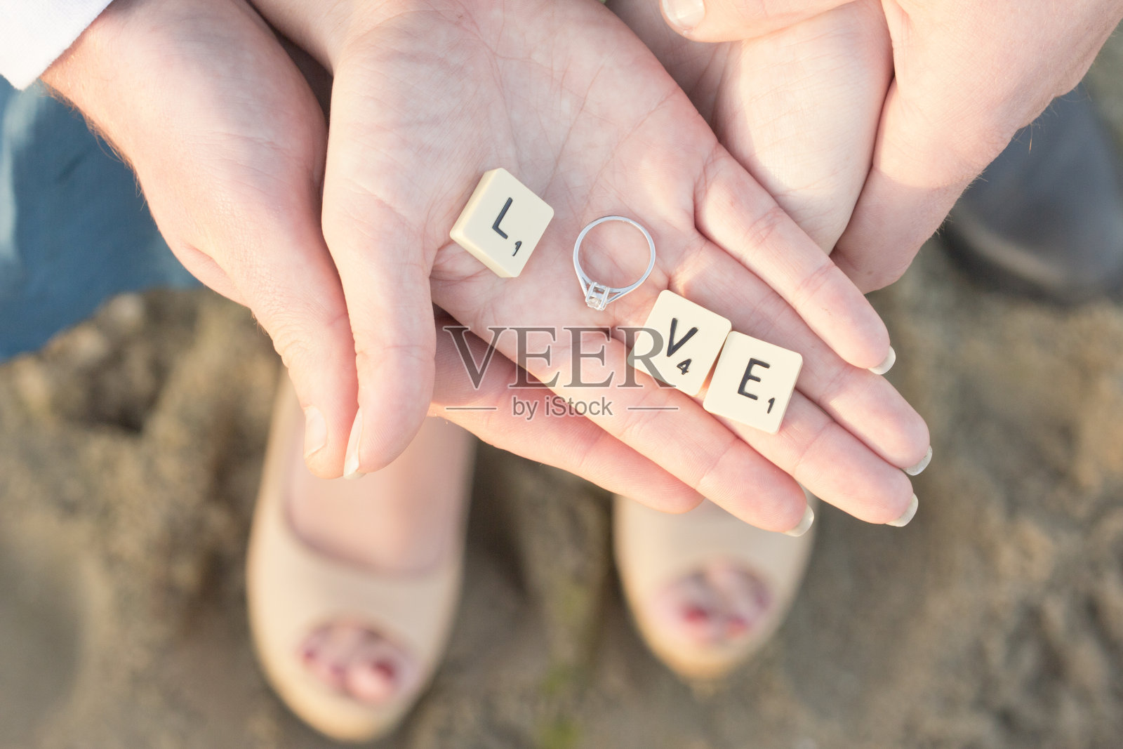 字母瓷砖和手上的订婚戒指照片摄影图片