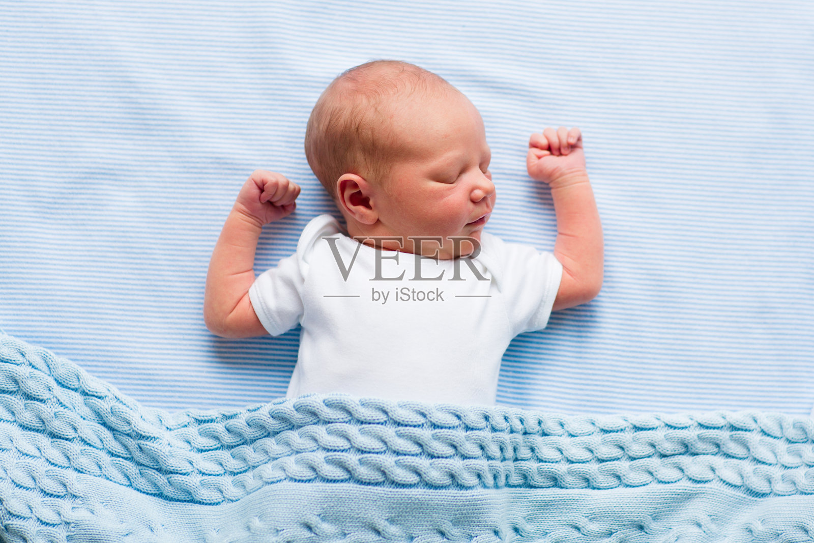 蓝色毯子下的新生男婴照片摄影图片