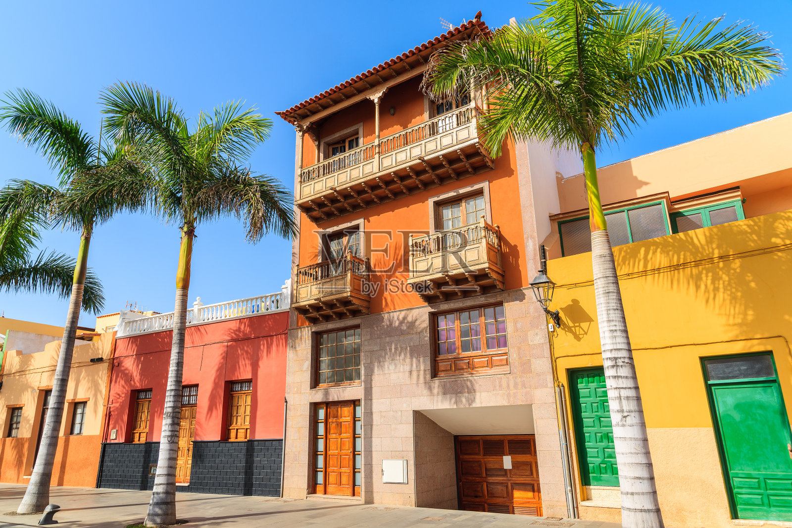西班牙加那利群岛特内里费岛的克鲁兹港街道上五颜六色的房子和棕榈树照片摄影图片
