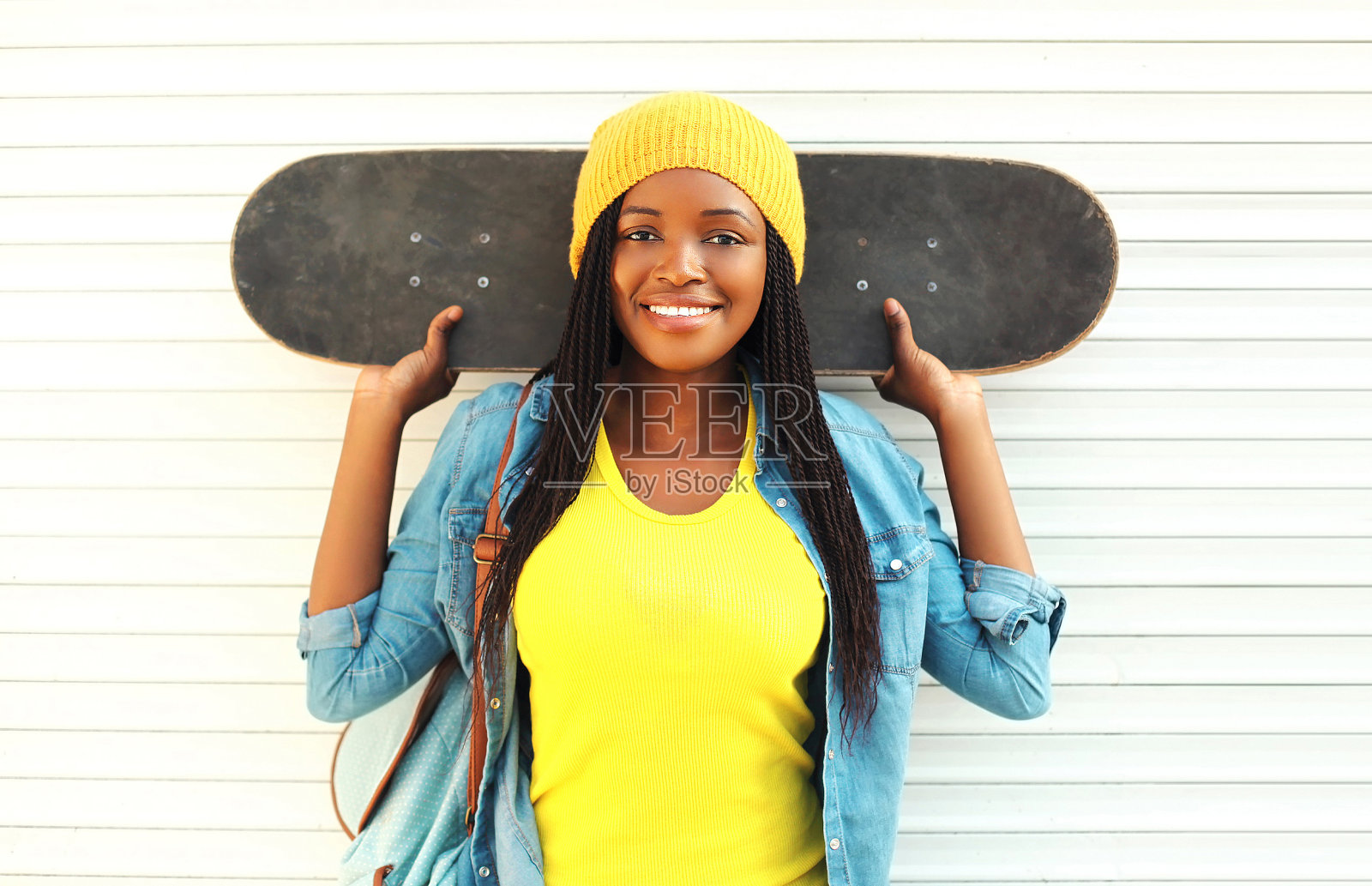 时尚漂亮的年轻微笑的非洲女人与滑板在co照片摄影图片