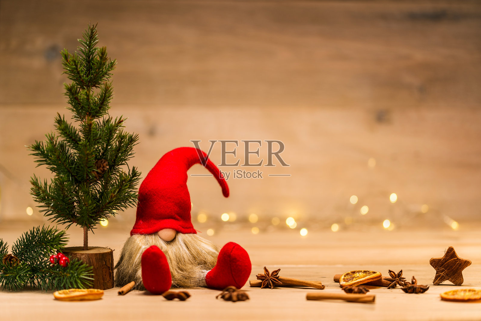 冷杉树和肉桂棒旁边的红色圣诞坏蛋照片摄影图片