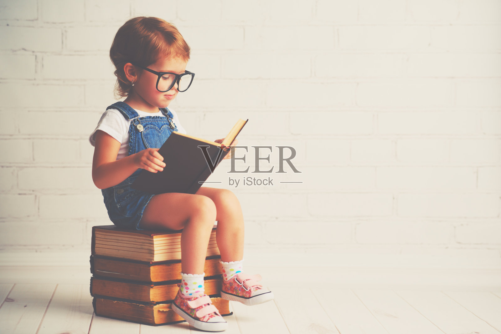 小女孩戴着眼镜看书照片摄影图片