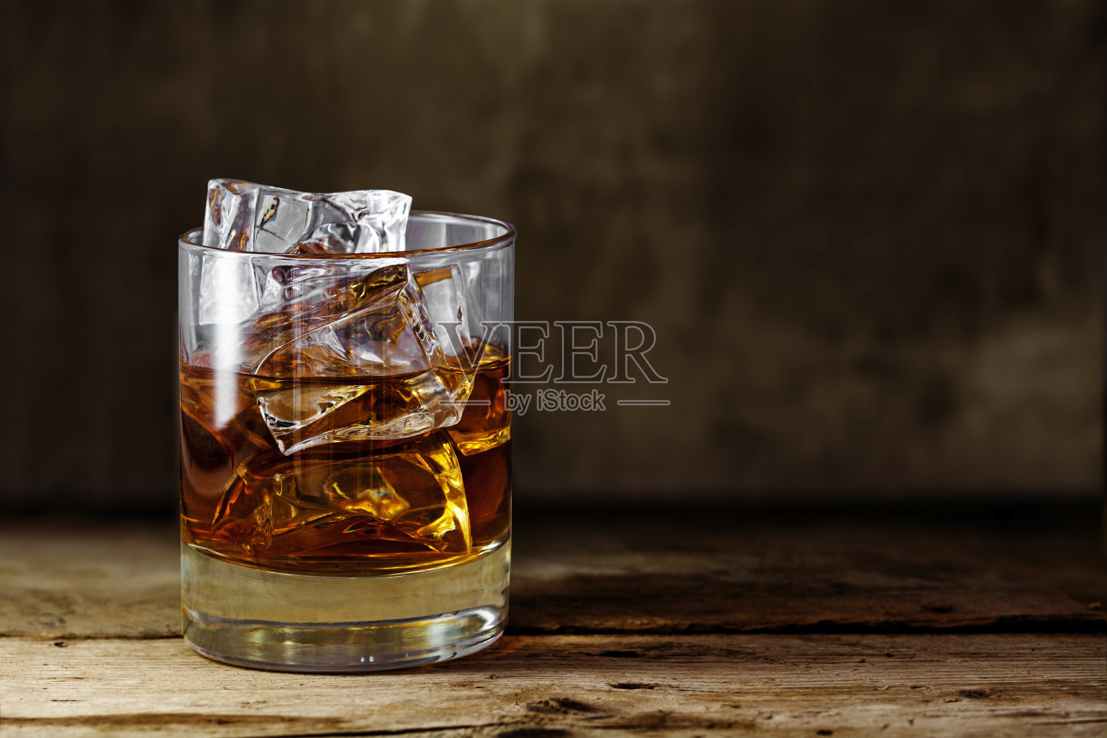 在质朴的木桌上放上加冰的苏格兰威士忌照片摄影图片