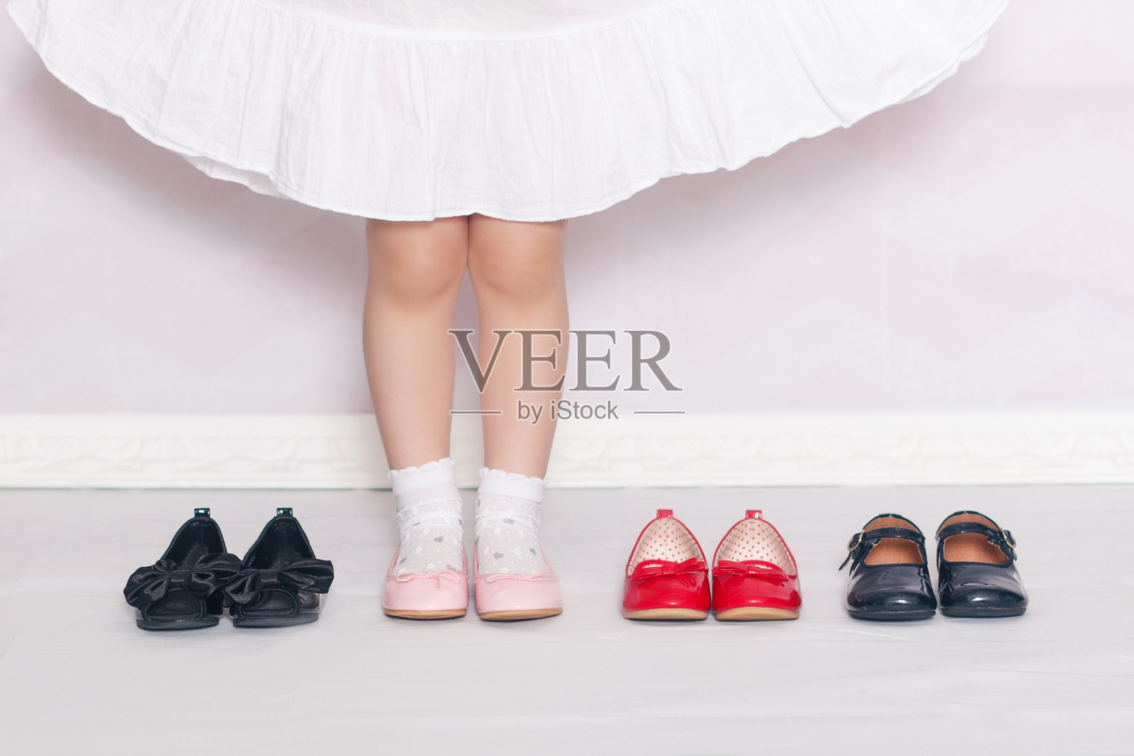 穿着白袜子，粉红色鞋子的小女孩的腿照片摄影图片