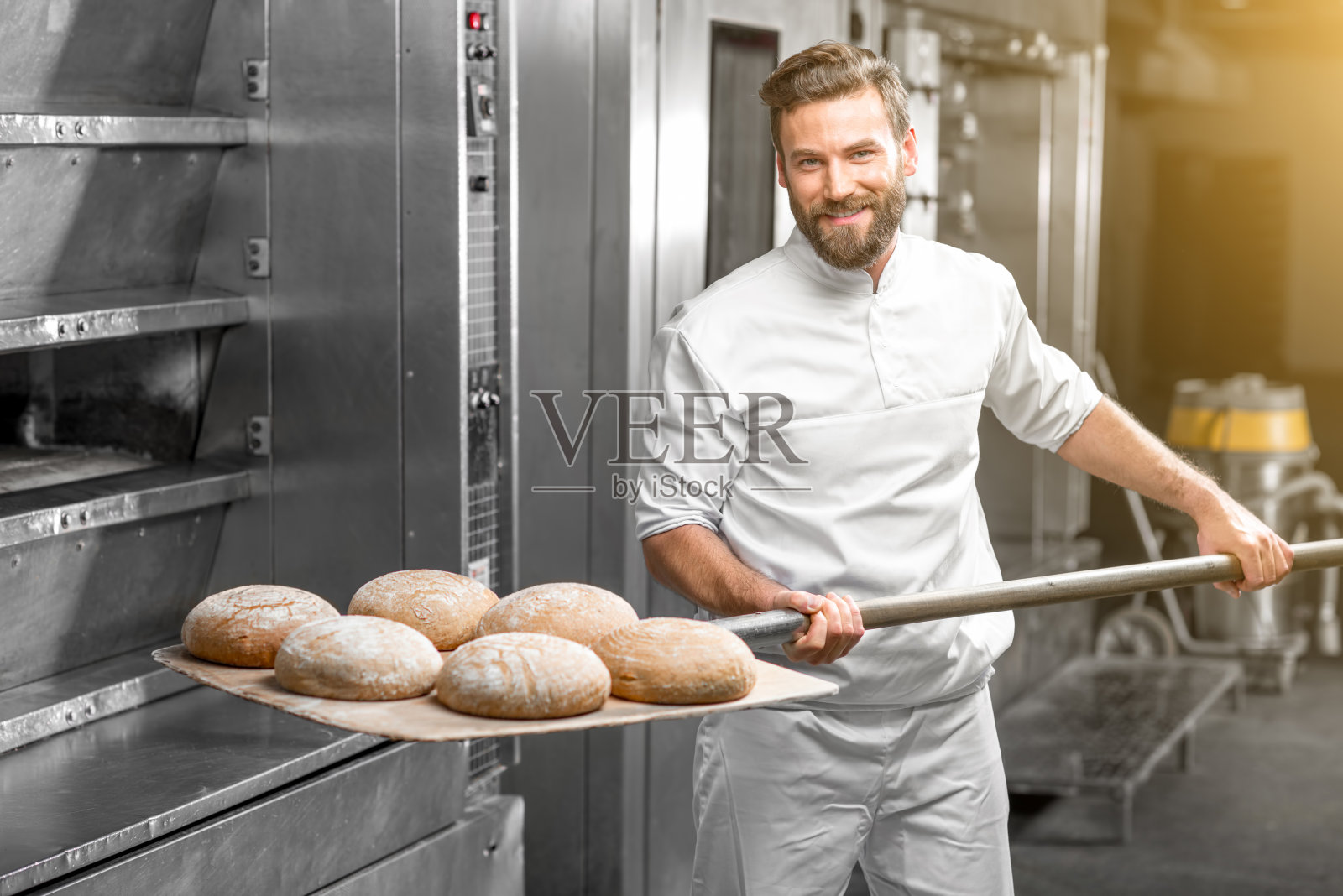 面包师从烤箱中拿出烤荞麦面包照片摄影图片