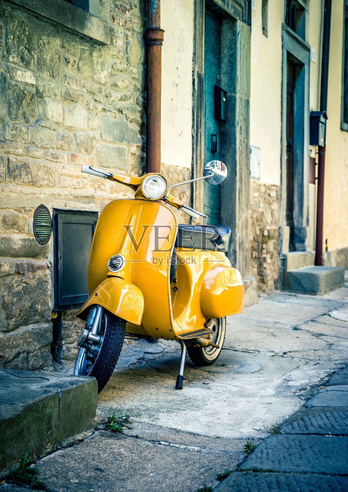 黄色摩托车在托斯卡纳科尔托纳镇照片摄影图片