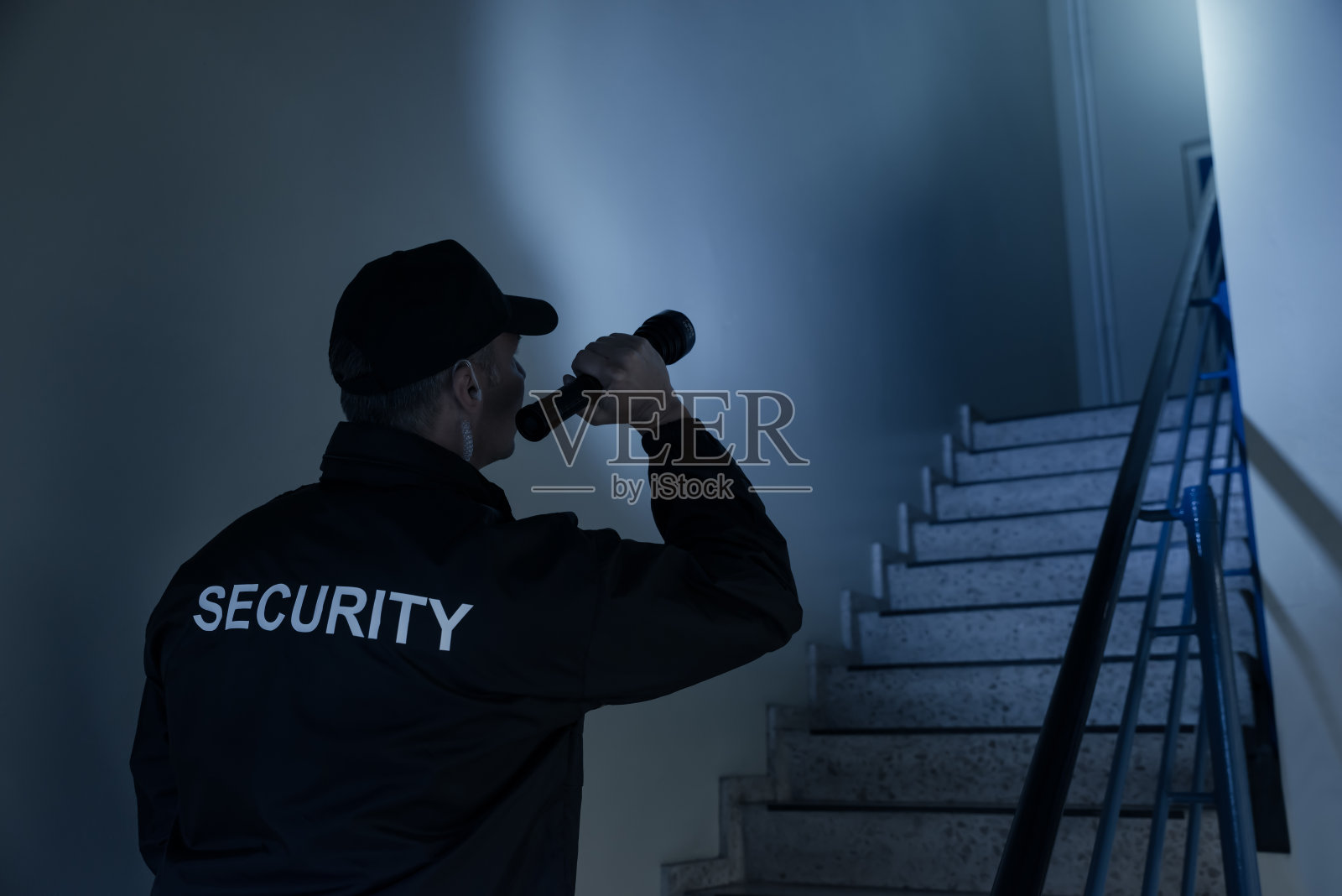 保安用手电筒在楼梯上搜索照片摄影图片