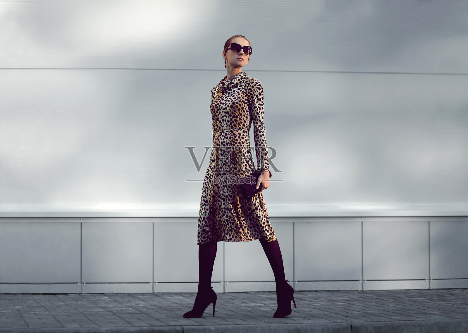 时尚女模特在豹纹裙走在傍晚的城市照片摄影图片