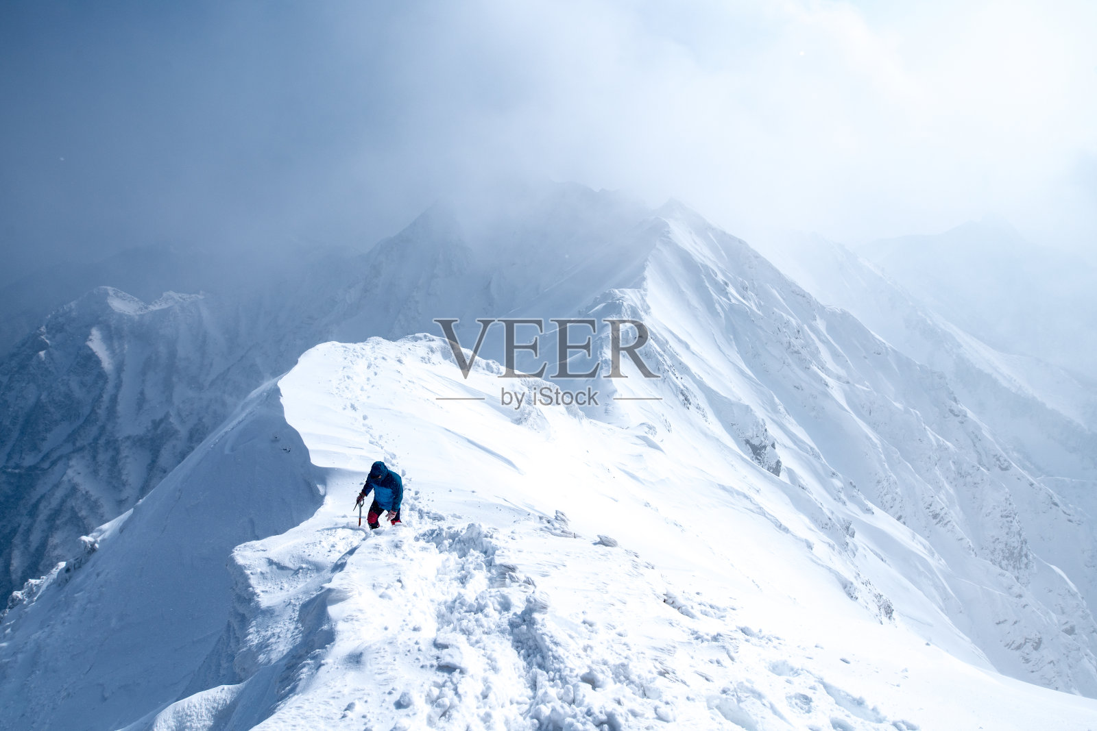 冰攀登者沿着山顶行走照片摄影图片