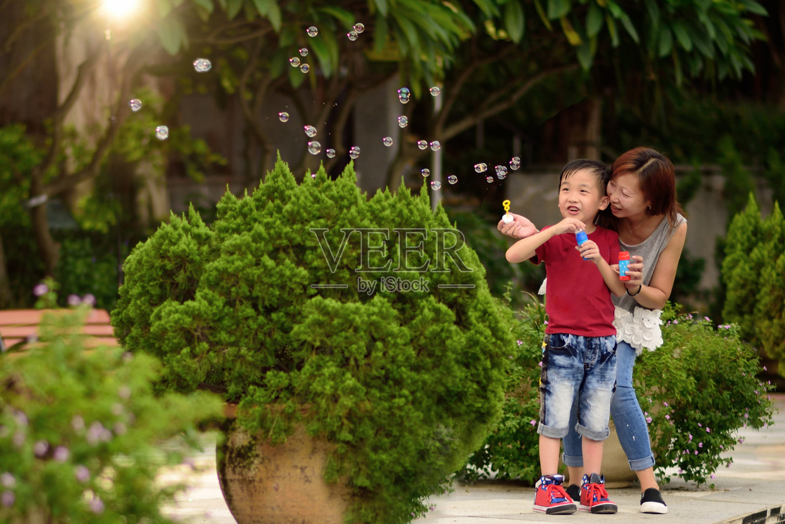 亚洲小孩和妈妈玩泡泡棒照片摄影图片