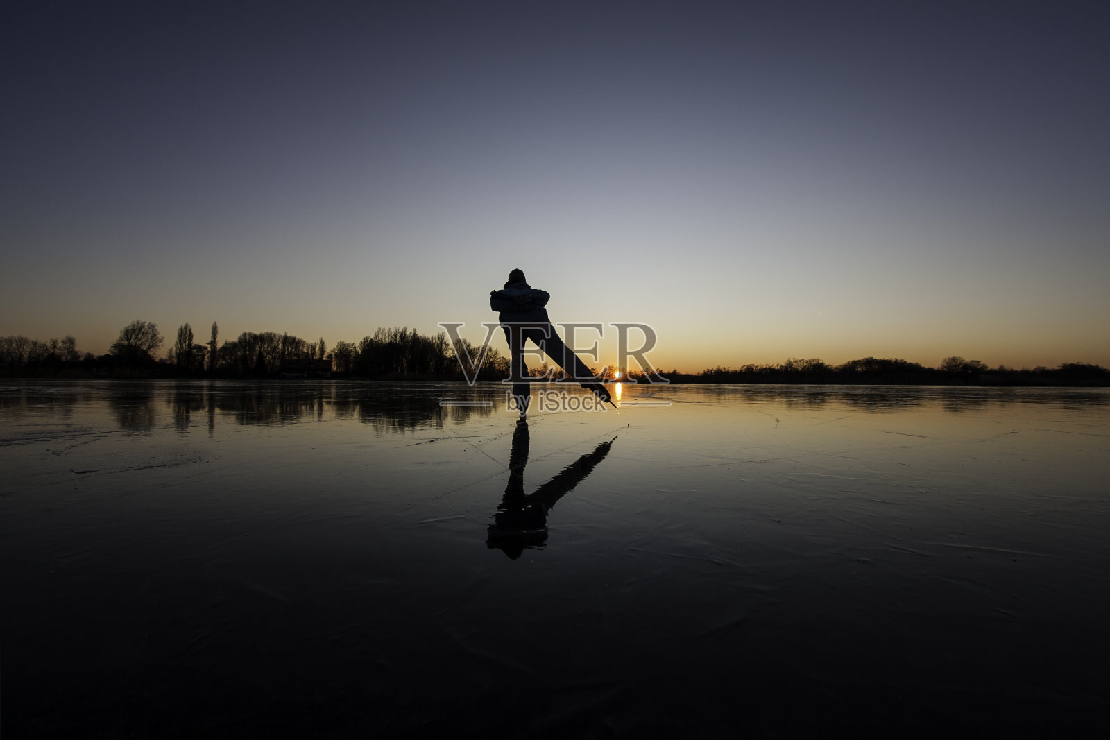 一个人滑冰的轮廓在黄昏与梯度天空照片摄影图片