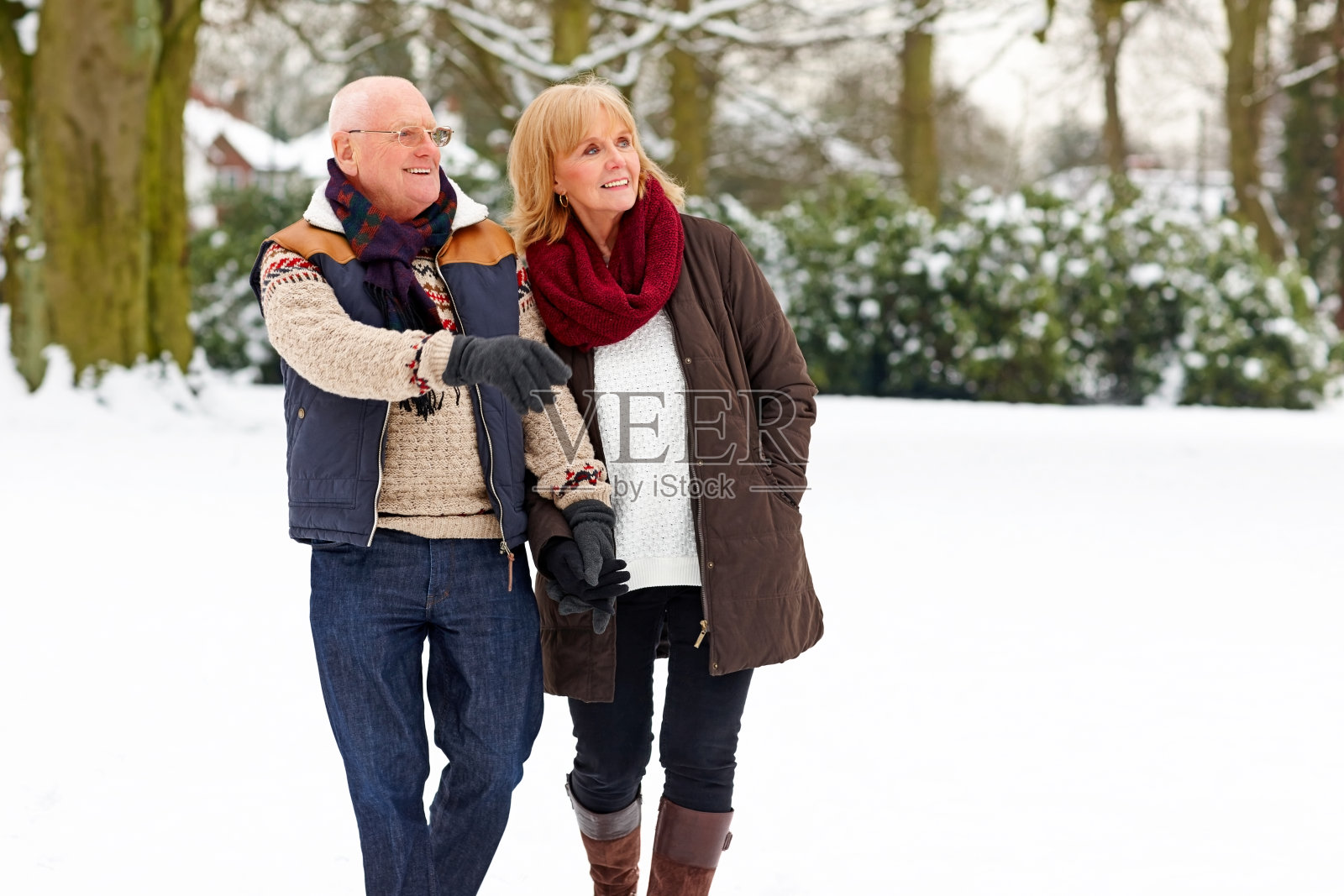 一对成熟的夫妇在雪地里散步照片摄影图片