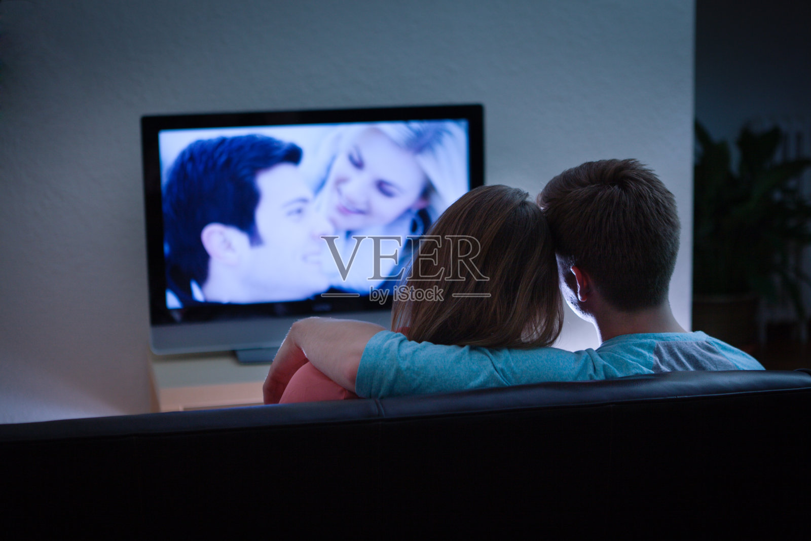 一对情侣在电视上一起看浪漫电影照片摄影图片