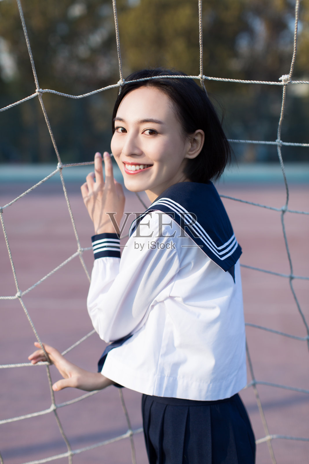 宽阔的足球场里有一个美丽的中国女学生照片摄影图片