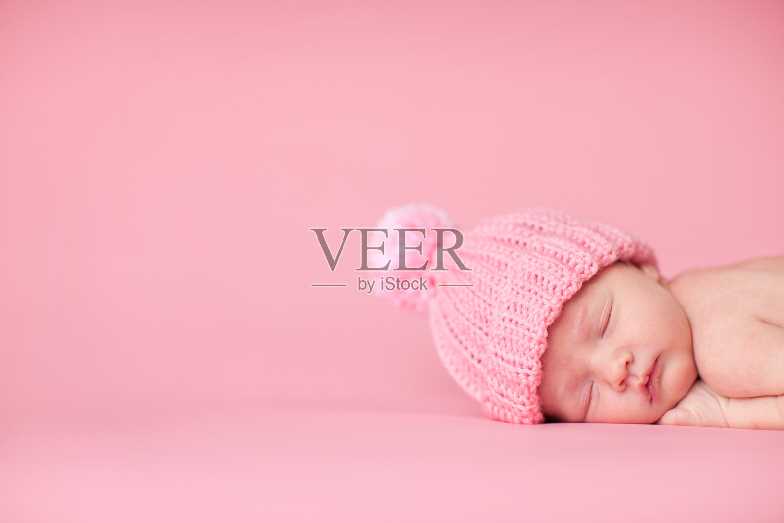 新生女婴在粉红色的背景下安静地睡觉照片摄影图片